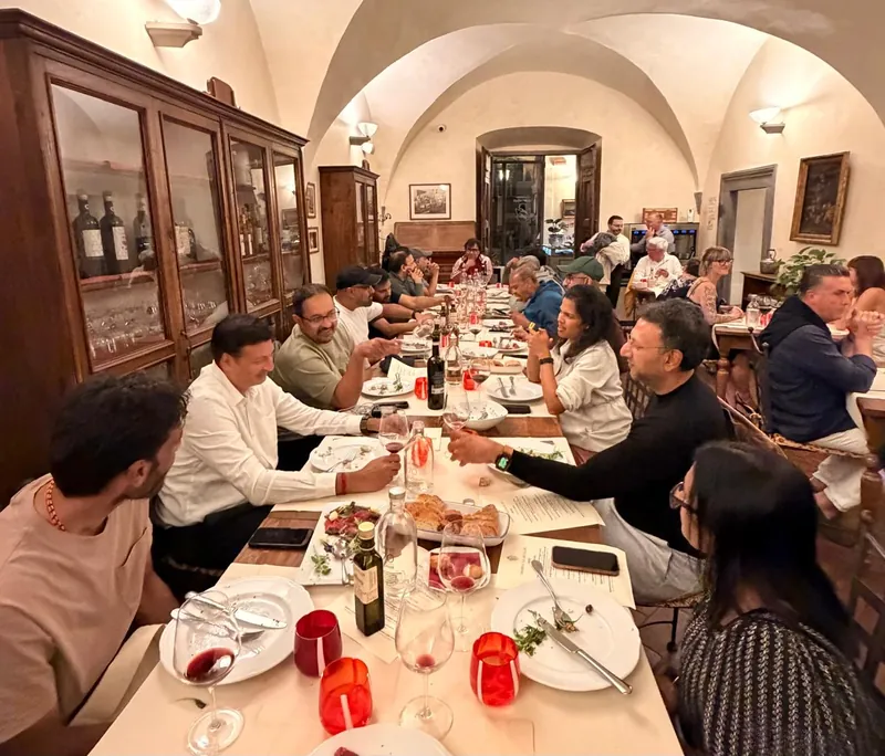 The group at a long dinner table in a vaulted dining room