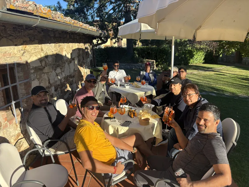 The group gathered for drinks at outdoor tables on a lawn