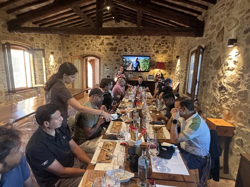 The group at a long table in a stone-walled room with wooden beams