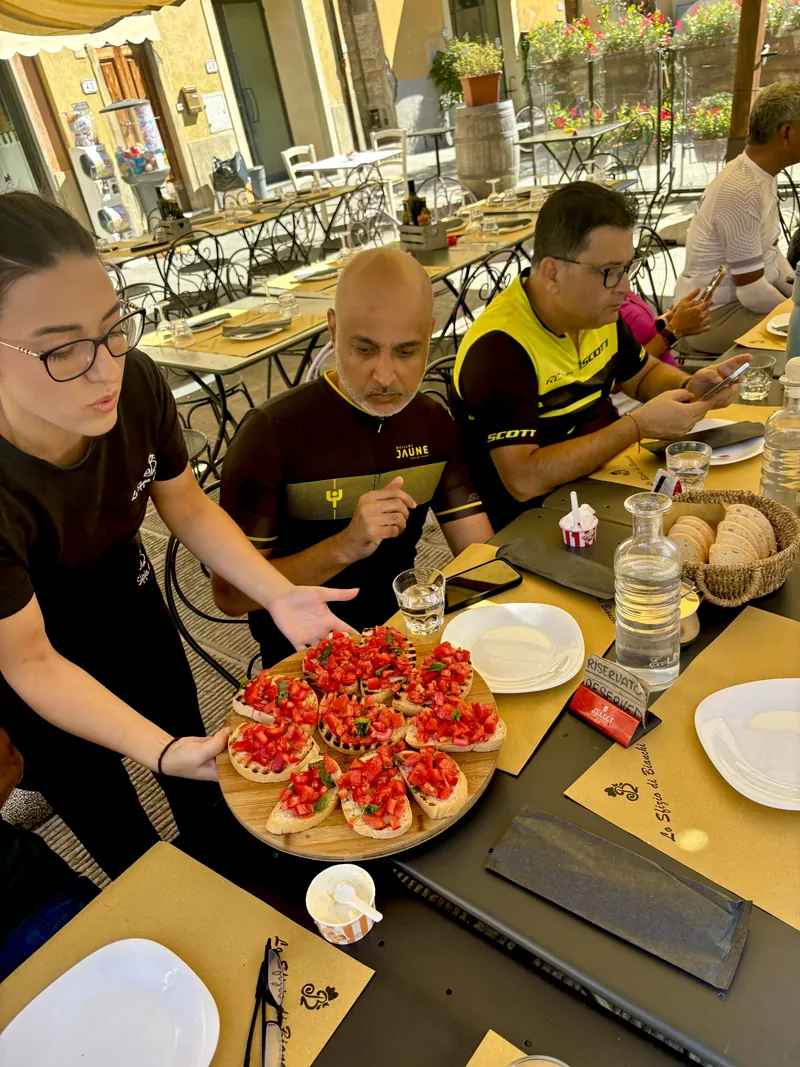 Riders at lunch as a platter of bruschetta arrives