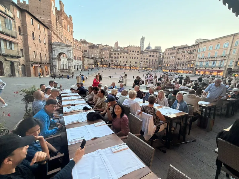 Diners at tables in Piazza del Campo in Siena in the evening