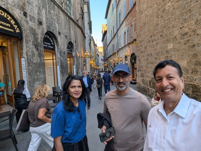 Three people on a narrow street in Siena