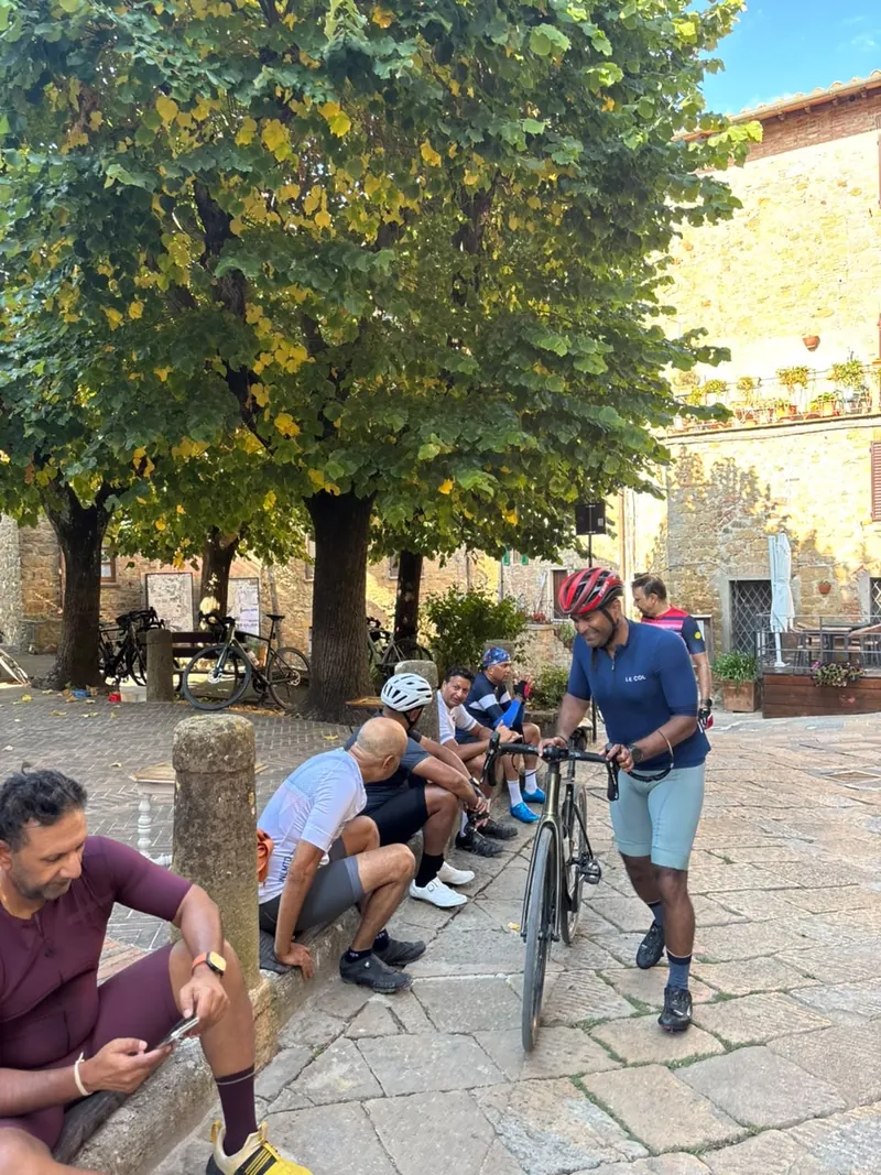 Riders resting in a village square beside their bikes