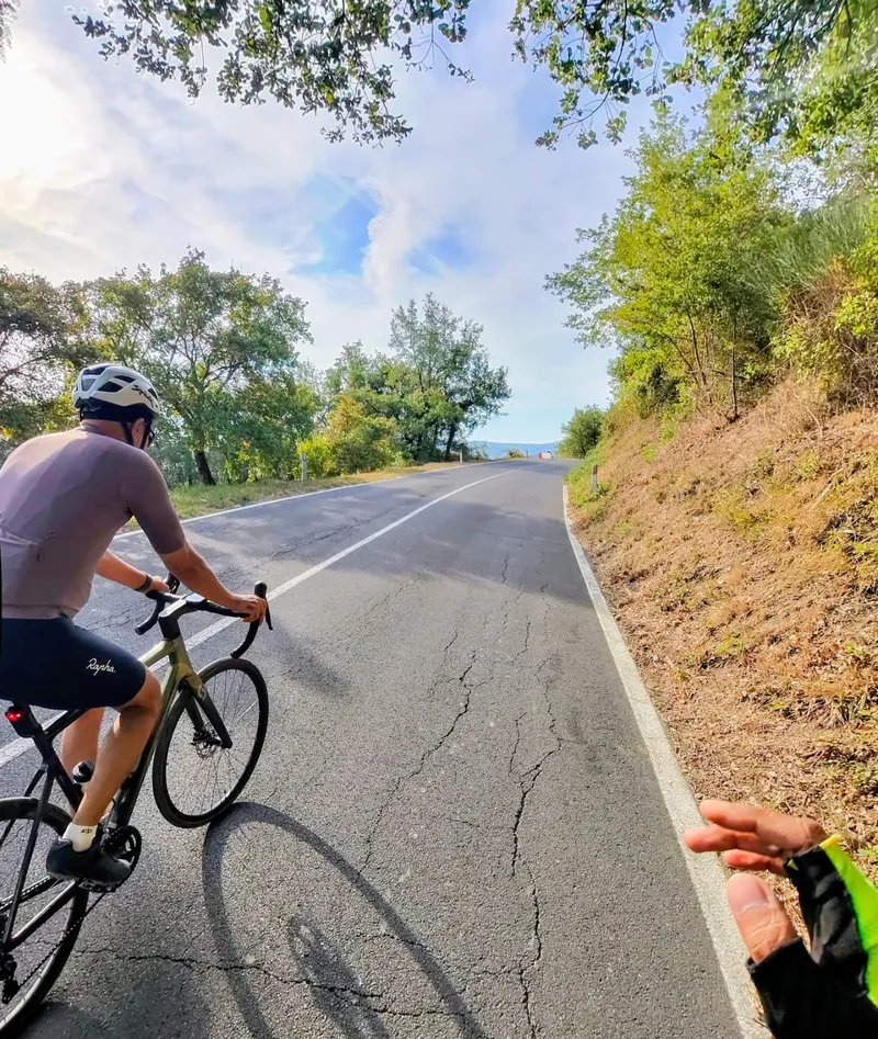 A rider on a quiet road through trees