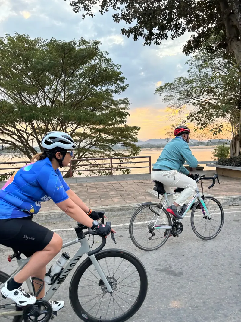 Two riders beside still water in the late afternoon
